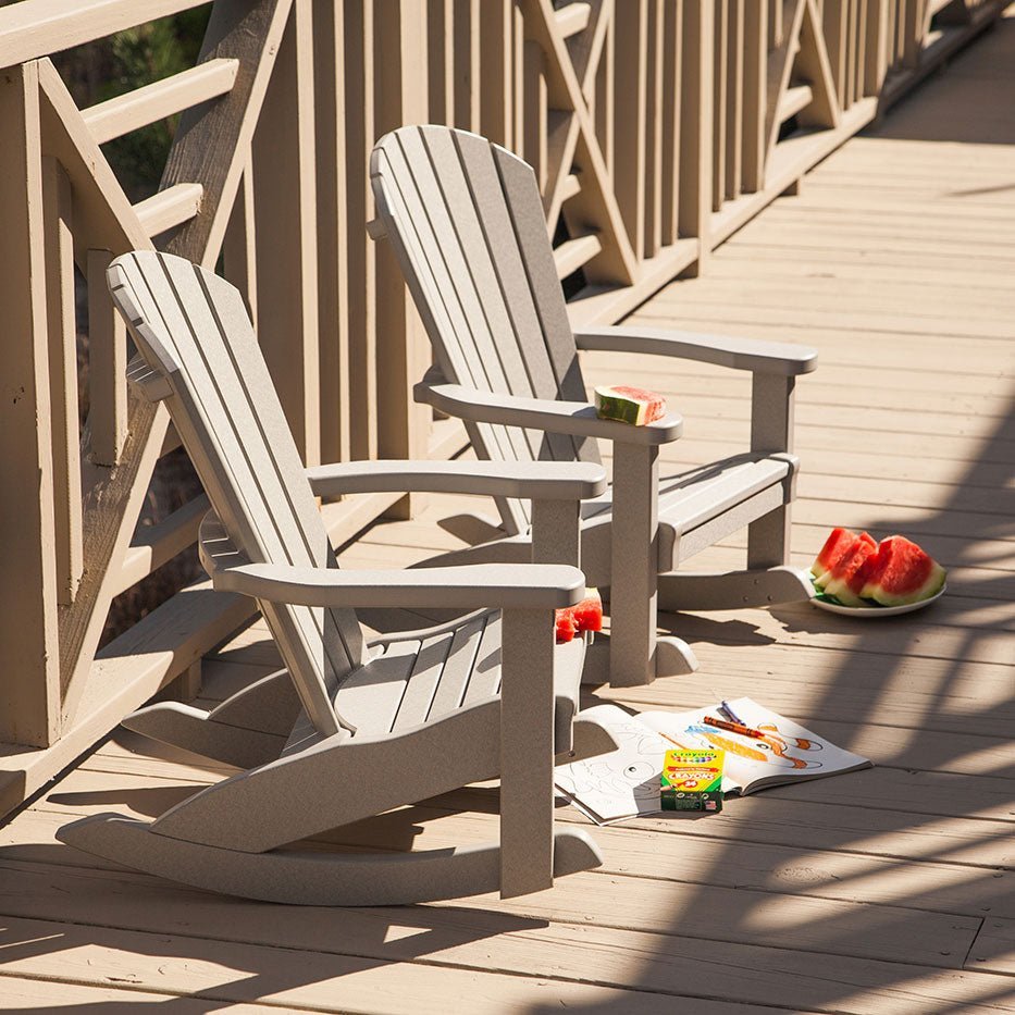 Two weatherwood child size poly Adirondack rockers on a sunny deck with crayons and watermelon on the boards