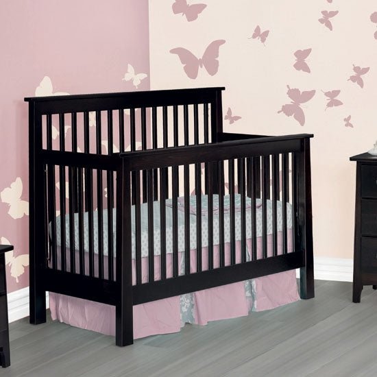 Black painted mission style convertible crib with square posts in a pink nursery with butterfly wall decals