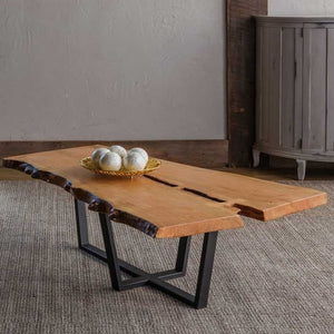 Live edge natural wood coffee table with a split plank top and a black steel X-shaped base on a woven rug