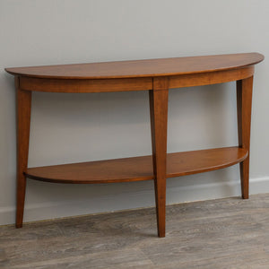 Curved demilune console table in a warm cherry finish with tapered legs and a half round lower shelf
