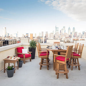 Rooftop patio with a brown poly fire pit bar table, red cushioned swivel chairs and a lounge chair by planters