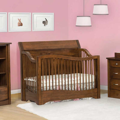 Warm brown sleigh style convertible crib with curved spindle sides in a pink nursery with pendant lights