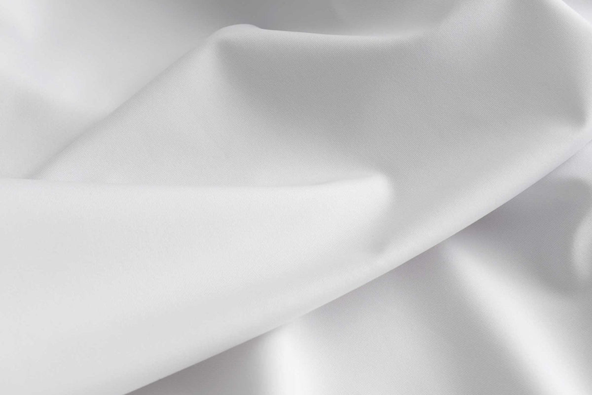 Close-up of the smooth white protector fabric draped in soft folds to show its cool-to-the-touch finish