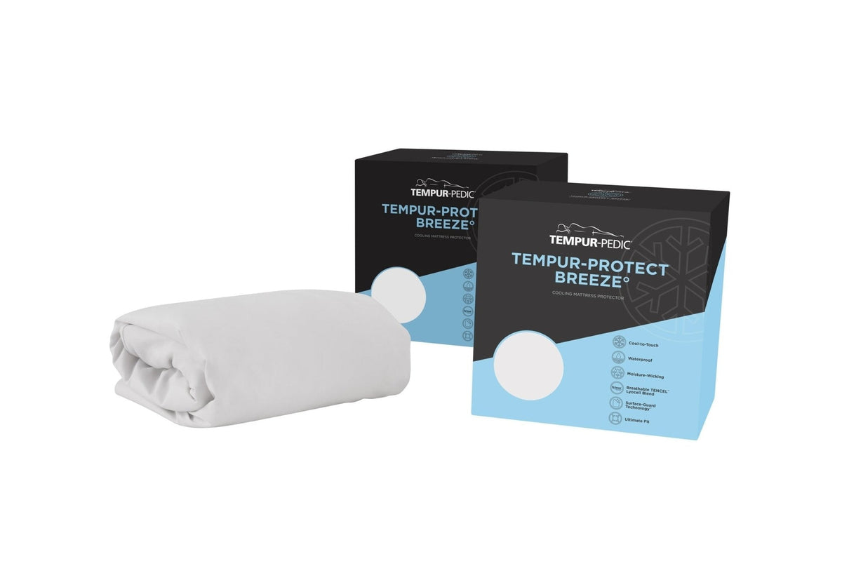 Cooling mattress protector shown folded in white beside its black and blue retail boxes on a white background