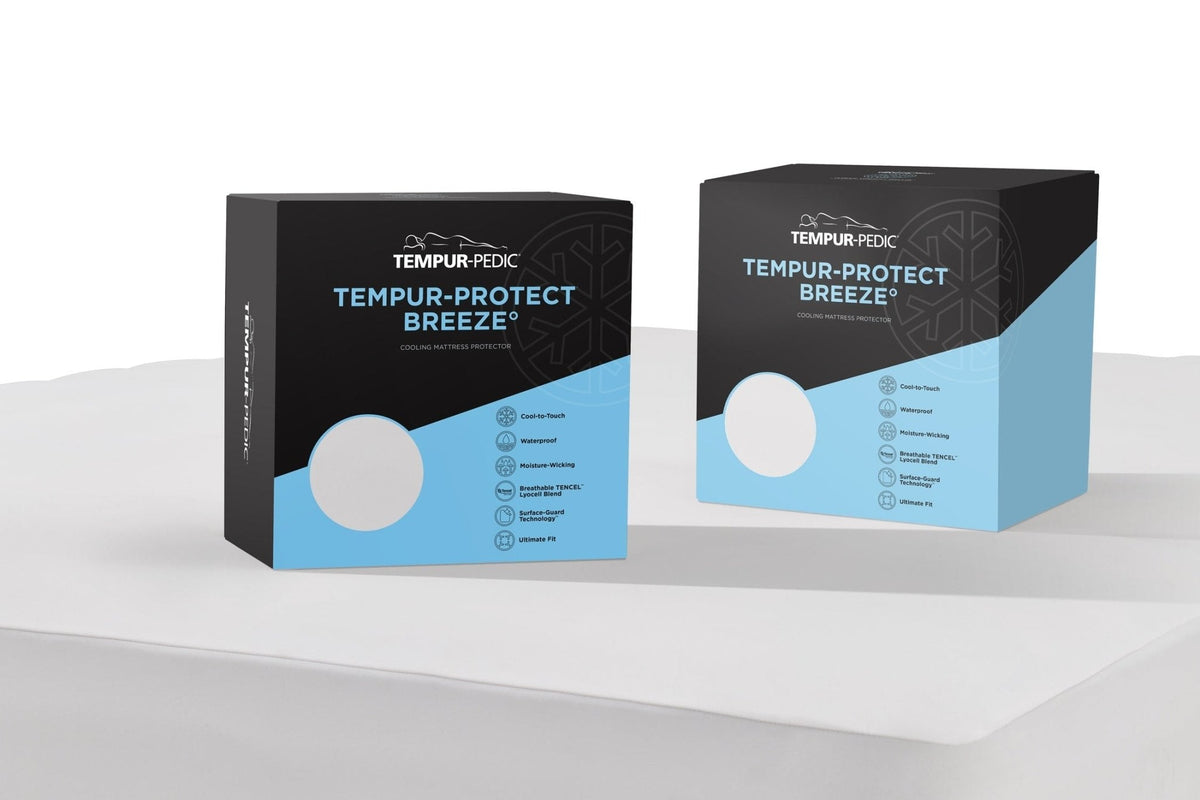 Two cooling mattress protector boxes standing on the white protector fabric, listing waterproof and cooling features