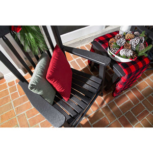 Overhead view of a black poly rocking chair with red and sage pillows and a buffalo check throw at Christmas